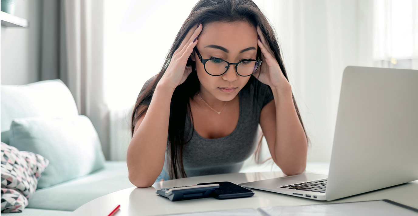 woman looking frustrated at her laptop